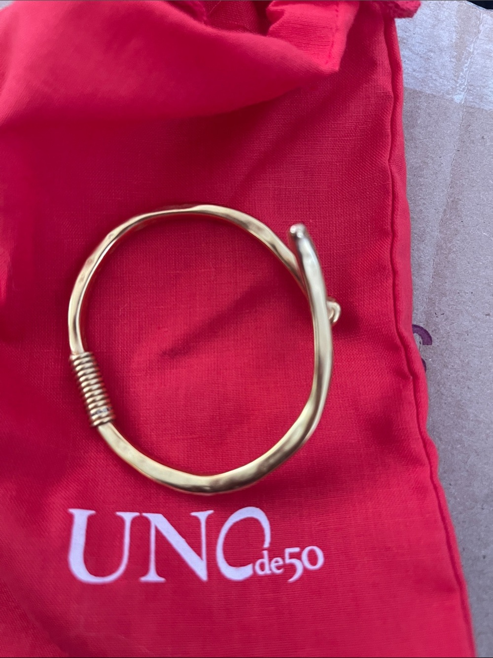 UNO de 50 Gold-Tone Hammered Coil Bypass Bracelet on Red Pouch